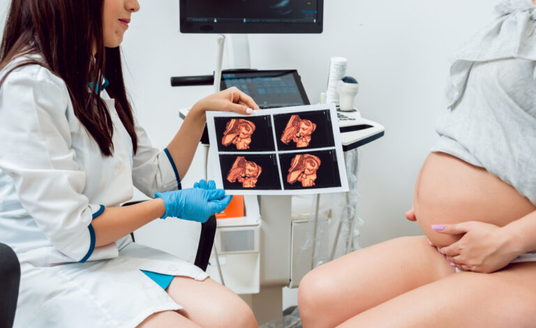 Gydytoja nėščiajai rodo vaisiaus ultragarso nuotraukas